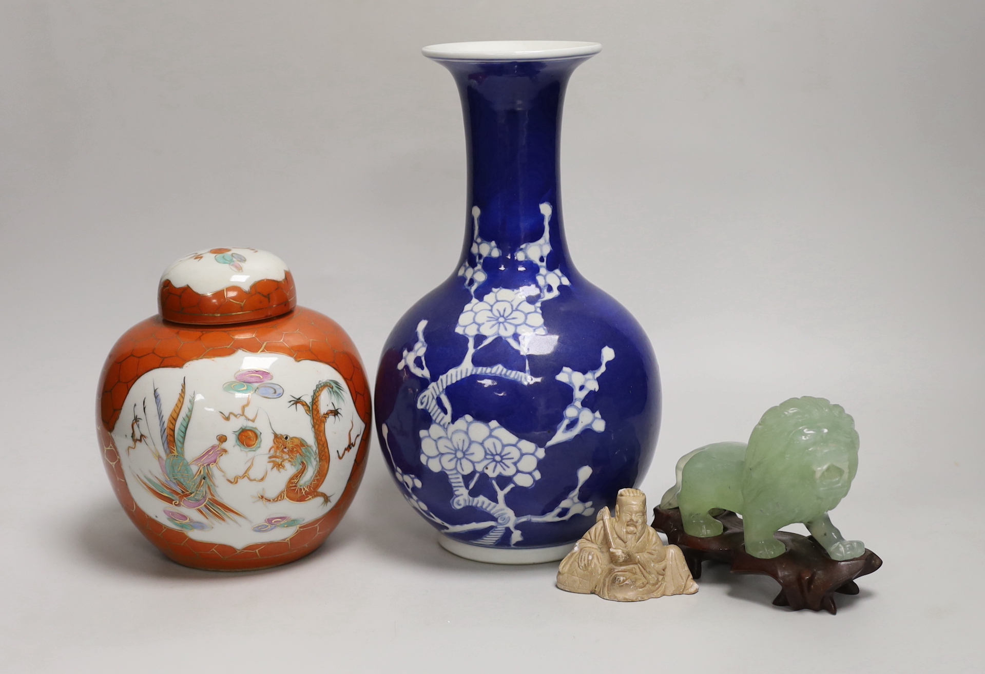 A Chinese blue and white vase, coral ground jar and cover, a bowenite carving of a lion and soapstone carving of a deity, tallest 24cm (4)